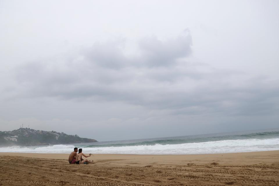 Tourists sit on the beach in Acapulco, Mexico (AP)