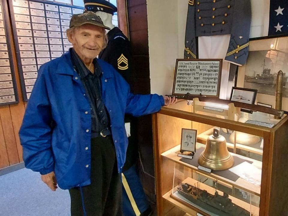 World War II veteran Joe Cooper poses with a Japanese sword and submarine bell at the Veterans History Museum of the Carolinas.