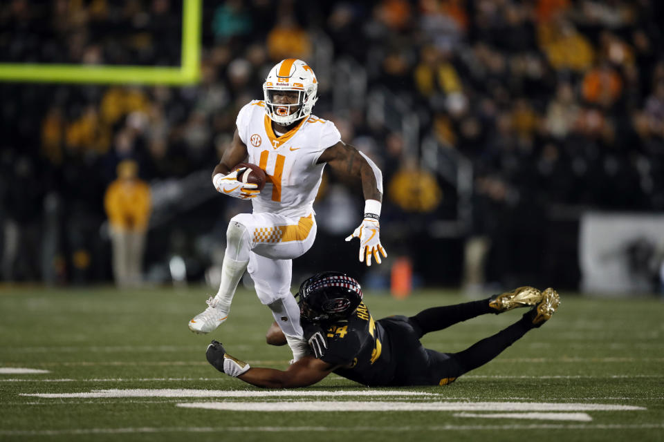 Tennessee running back John Kelly (L) slips past Missouri linebacker Terez Hall during the first half of an NCAA college football game Saturday, Nov. 11, 2017, in Columbia, Mo. (AP Photo/Jeff Roberson)