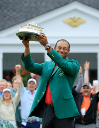 Tiger Woods lifts the Masters champions trophy after having donned the green jacket symbolic of supremacy at Augusta National