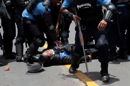 A riot policeman lies injured during clashes with university students protesting over a controversial reform to the pension plans of the Nicaraguan Social Security Institute (INSS) in Managua, Nicaragua April 20, 2018. REUTERS/Oswaldo Rivas