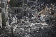 Palestinians inspect the rubble of their destroyed homes after being targeted by Israeli airstrikes in town of Beit Lahiya, northern Gaza Strip, Thursday, May 13, 2021. Gaza braced for more Israeli airstrikes and communal violence raged across Israel after weeks of protests and violence in Jerusalem. (AP Photo/Khalil Hamra)