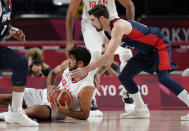 Iran's Arsalan Kazemi (41), left, and France's Nando de Colo (12) scramble for a loose ball during men's basketball preliminary round game at the 2020 Summer Olympics, Saturday, July 31, 2021, in Saitama, Japan. (AP Photo/Eric Gay)