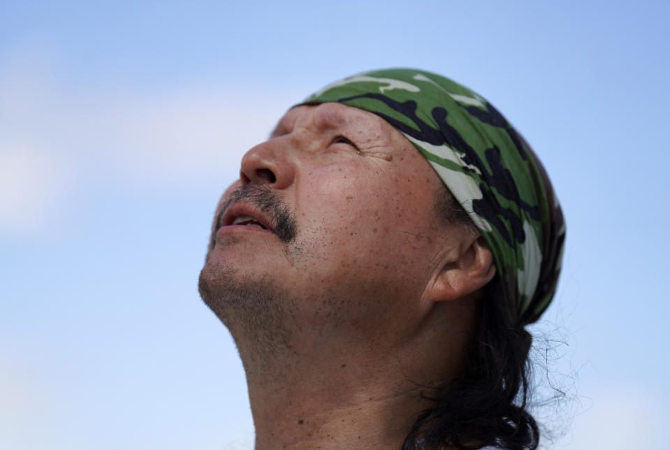 Joseph Zoe looks toward the sky as he talks about his personal connection with the Lac Ste. Anne pilgrimage site during a press conference along the shores of the sacred lake in Alberta on Wednesday, July 20, 2022. Pope Francis is scheduled to make a pilgrimage to the water during his visit to the Canadian province. (AP Photo/Jessie Wardarski)