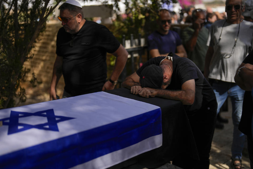A man mourns during the funeral of Ronny Levi at Kibbutz Revivim, southern Israel, Sunday, Oct. 22, 2023. Levi was killed at kibbutz Beeri by Hamas militants on Saturday 7 as they carried out an unprecedented, multi-front attack that killed over 1,000 Israelis. (AP Photo/Francisco Seco)