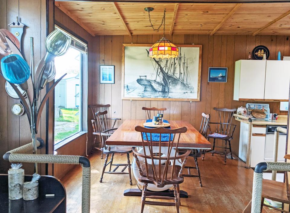 The kitchen with wooden walls, floor, and ceiling, window on the left