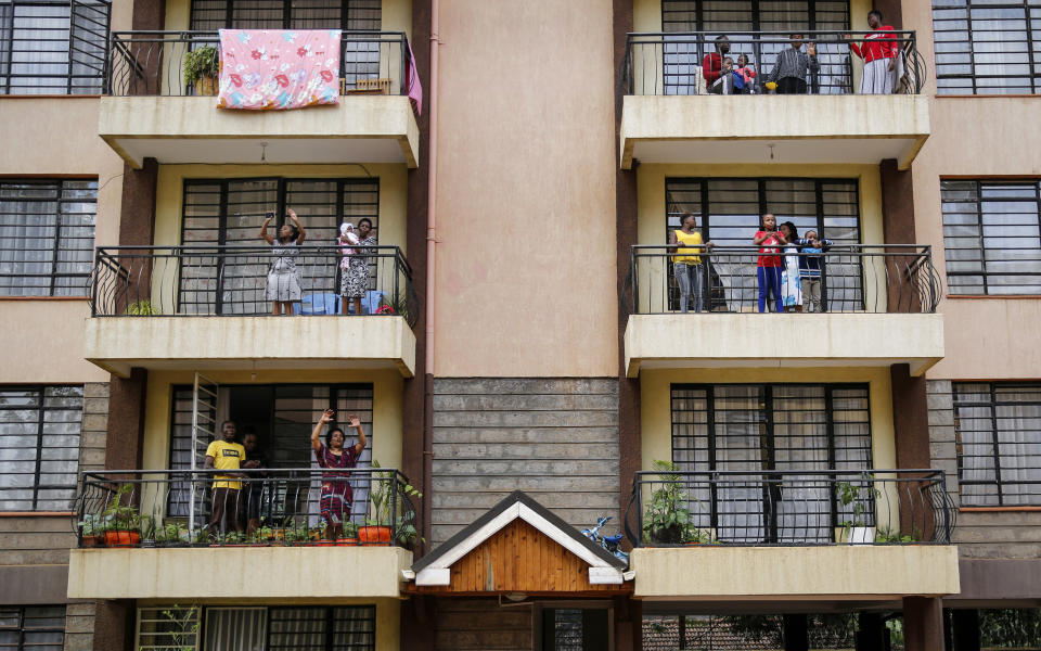 FILE - In this Sunday, May 17, 2020 file photo, residents sing from their apartment balconies as Rev. Paul Machira preaches and sings to them below, due to restrictions on public religious services to curb the spread of the coronavirus, at an apartment block in Nairobi, Kenya. The COVID-19 pandemic is testing the patience of some religious leaders across Africa who worry they will lose followers, and funding, as restrictions on gatherings continue. (AP Photo/Brian Inganga, File)