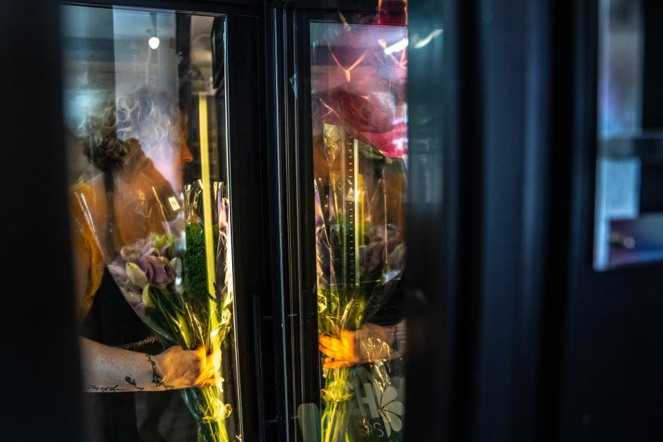 Jen Drake pulls flowers out of the cooler to create bouquets.