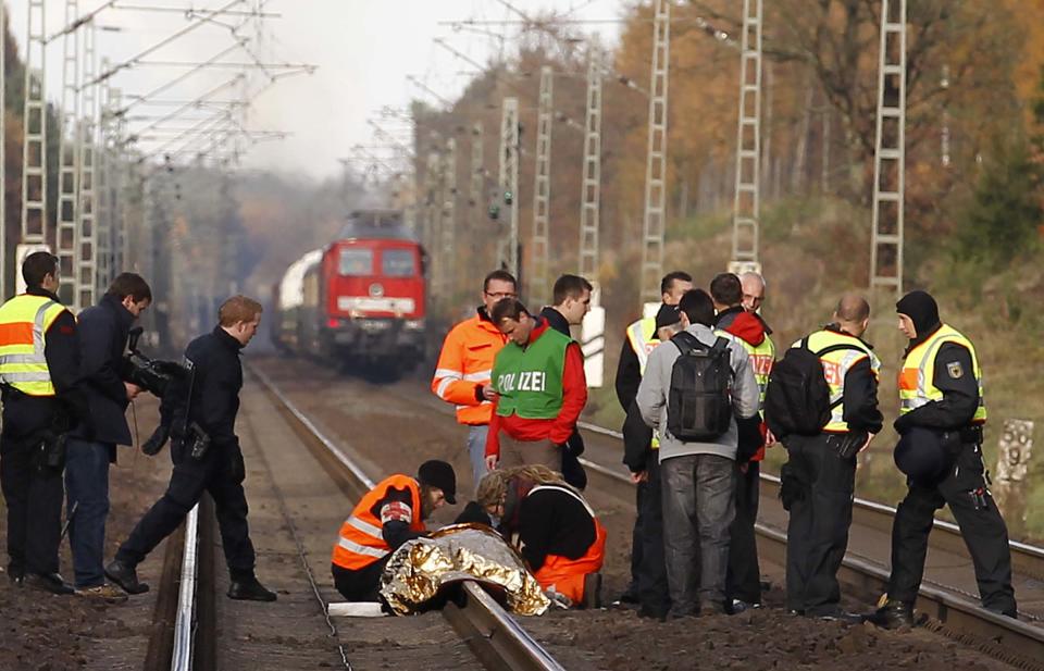 Polizisten lösen vor der Ankunft eines Castor-Transports einen angeketteten Atomgegner vom Gleis (Bild: Reuters/Kai Pfaffenbach)