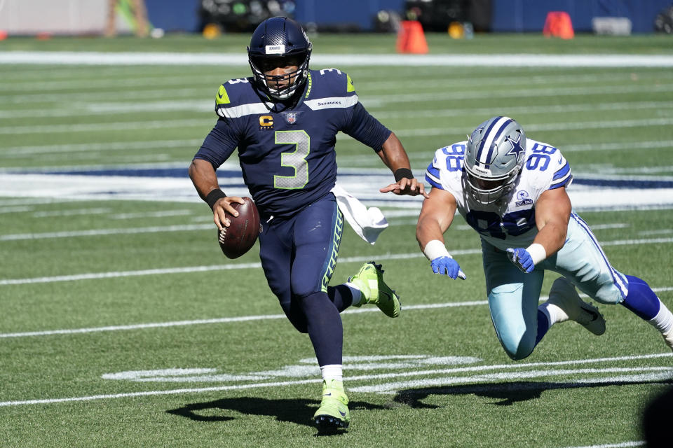 Russell Wilson scrambles with the ball trying to avoid a sack.