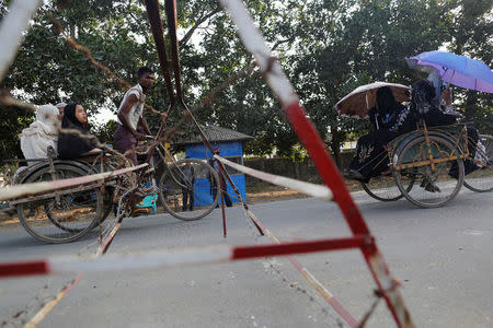 Rohingya women ride on rickshaws in front of a check point outside a refugee camp in Sittwe in the state of Rakhine, Myanmar March 3, 2017. REUTERS/Soe Zeya Tun