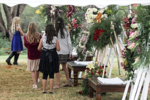 Girls attend the wake of women and children killed in an attack authorities have blamed on a drug cartel