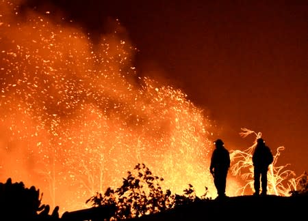 FILE PHOTO: Firefighters keep watch on the Thomas wildfire in the hills and canyons outside Montecito, California