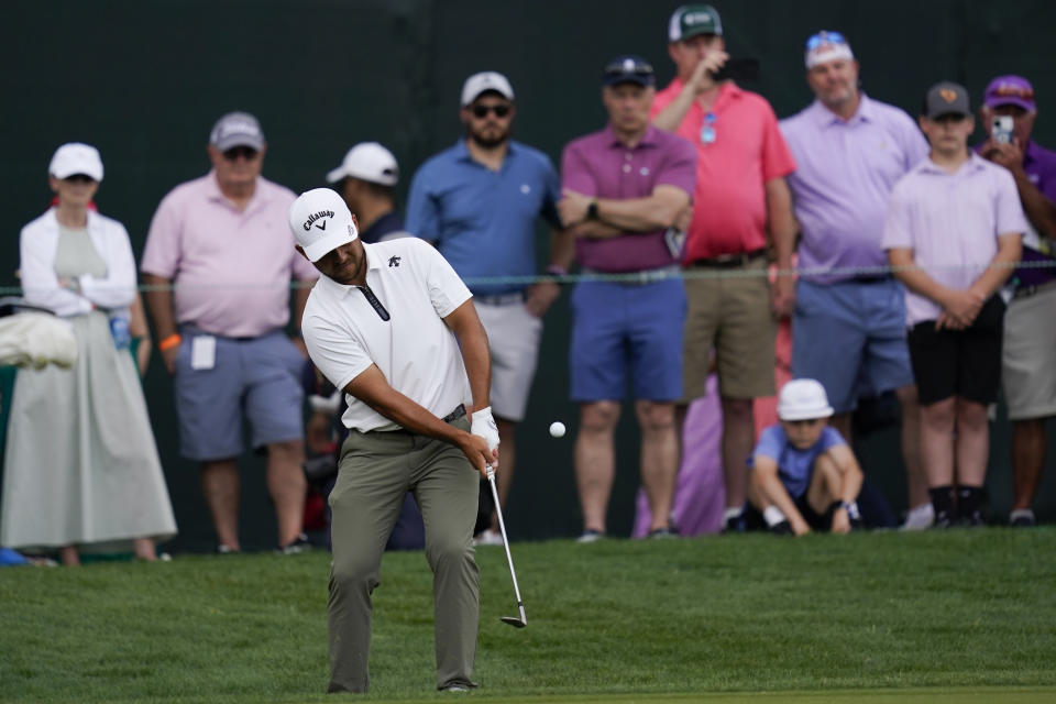 Xander Schauffele, foreground, hits to the green on the 18th hole during the second round of the Wells Fargo Championship golf tournament at Quail Hollow, Friday, May 10, 2024, in Charlotte, N.C. (AP Photo/Erik Verduzco)