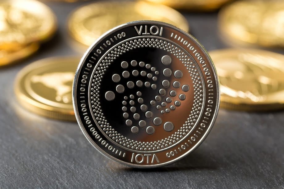 Eine IOTA-Münze, im Hintergrund weitere IOTA-Coins