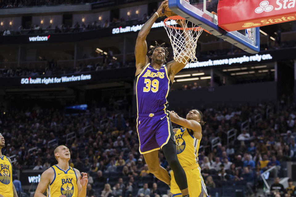 Los Angeles Lakers center Dwight Howard (39) dunks the ball as Golden State Warriors guard Jordan Poole (3) watches in the first half of an NBA basketball game in San Francisco Saturday, Feb. 8, 2020. (AP Photo/John Hefti)