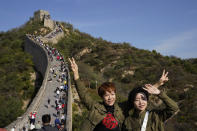 Tourists pose for photos along a stretch of the Badaling Great Wall of China on the outskirts of Beijing, Tuesday, Oct. 6, 2020. Chinese tourists took 425 million domestic trips in the first half of the eight-day National Day holiday, generating $45.9 billion in tourism revenue, according to China's ministry of culture and tourism. The holiday this year, which coincides with the Mid-Autumn Festival, will be a litmus test of whether China's tourism industry can bounce back after being battered by COVID-19. (AP Photo/Ng Han Guan)