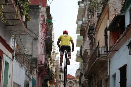 Felix Guirola, 52, rides a homemade bike with an advertising banner in Havana, Cuba, July 20, 2016. REUTERS/Alexandre Meneghini