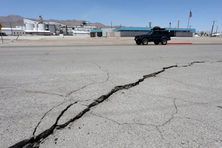 A crack extends across the highway after an earthquake broke, triggered by a previous day quake, near the epicenter in Trona