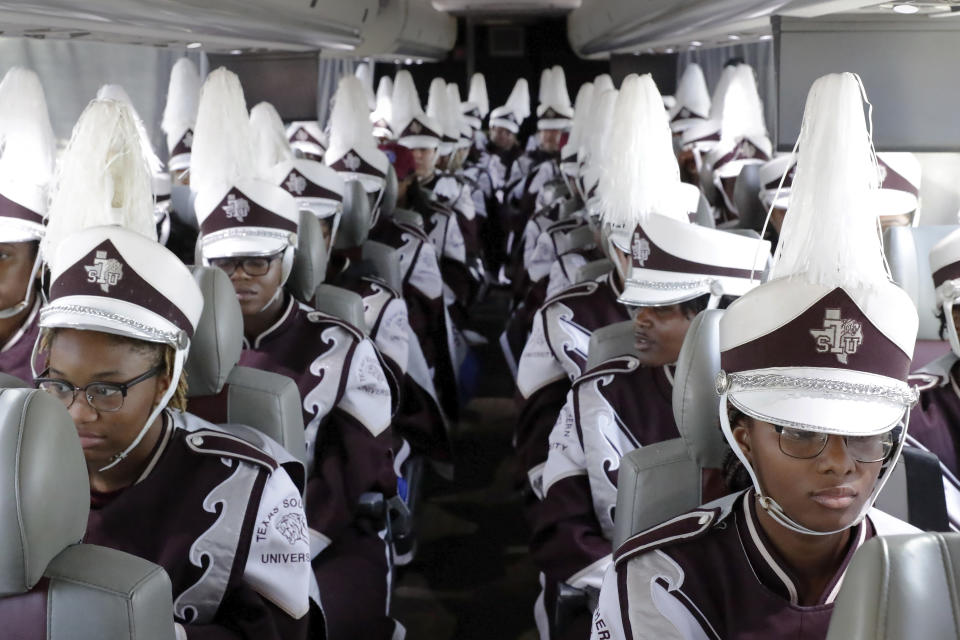 Members of the Texas Southern University Ocean of Soul marching band wait in full uniform on air conditioned buses, instead of outside in 100-degree temperatures, before heading into the venue before the start of the 2023 National Battle of the Bands, a showcase for HBCU marching bands, held at NRG Stadium, Saturday, Aug. 26, 2023, in Houston. (AP Photo/Michael Wyke)