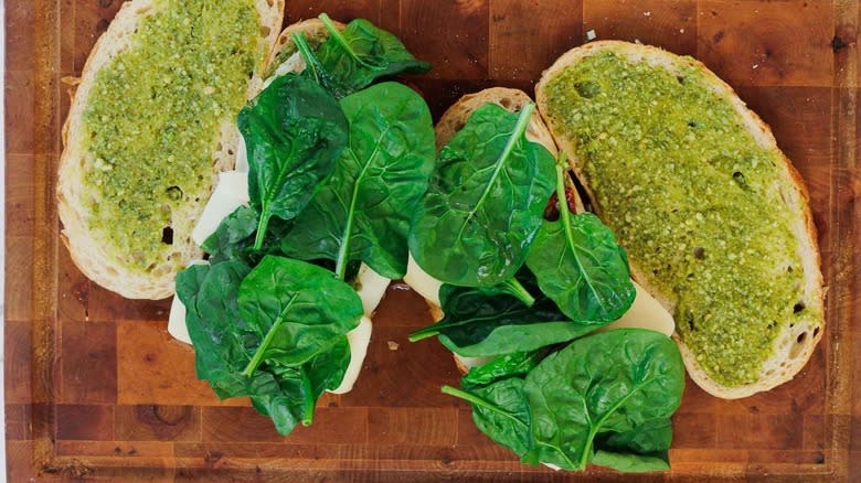 assembling two sandwiches with pesto