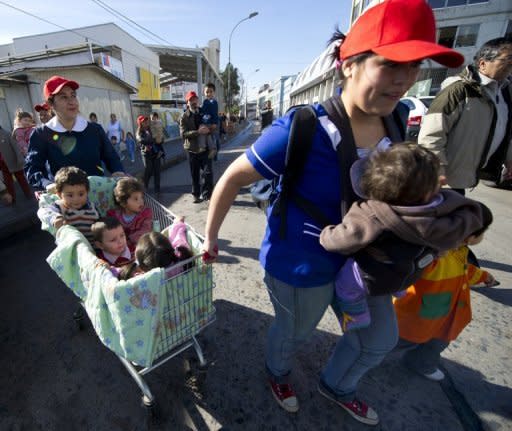 Las profesoras de un jardín de infancia de la ciudad chilena de Valparaíso evacuan a sus alumnos ante una amenaza de tsunami el 28 de mayo de 2012. Unos expertos de Colombia, Ecuador, Chile y Perú iniciaron el martes una reunión en Lima, auspiciada por la UNESCO, a fin de diseñar un sistema de alerta temprana de tsunami que evite los efectos destructivos de ese fenómeno en sus costas. (AFP/Archivo | Martín Bernetti)