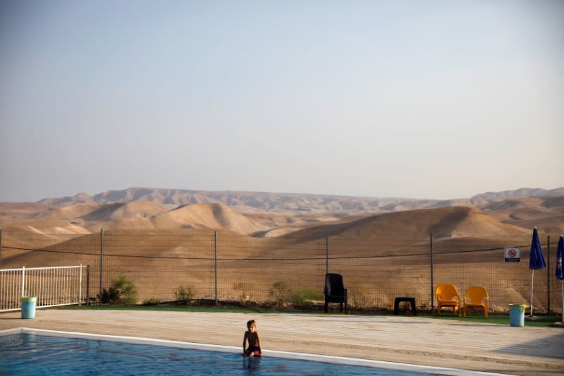 FILE PHOTO: A boy sits by the swimming pool at the Israeli settlement of Vered Yericho in the occupied West Bank