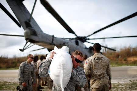 A soldier carries relief aid after Hurricane Matthew passes in Jeremie, Haiti, October 9, 2016. REUTERS/Carlos Garcia Rawlins