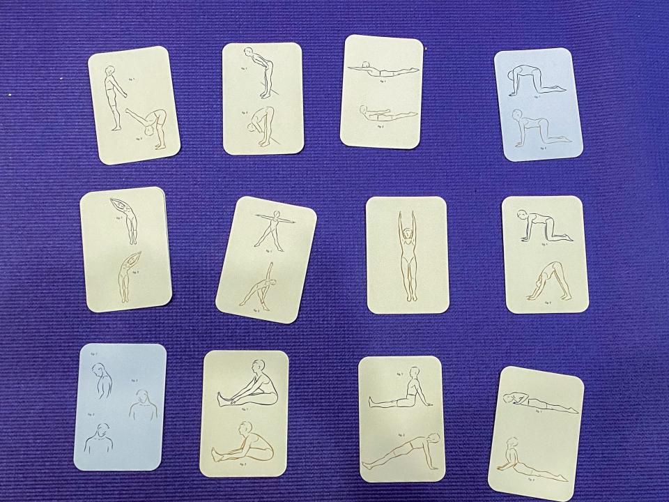 12 yoga cards in rows of four on top of a purple yoga mat