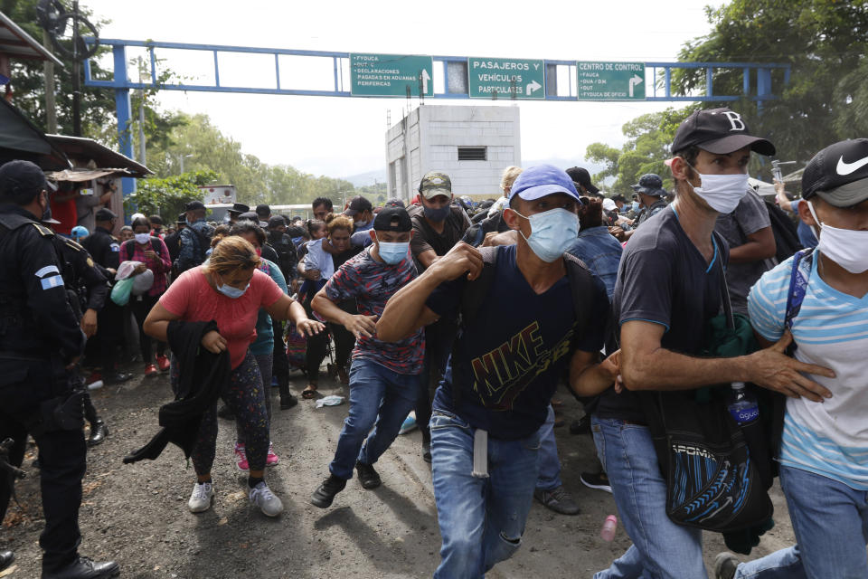 Migrants attempt to cross the border from Corinto, Honduras, into Corinto, Guatemala, Thursday, Oct. 1, 2020. Hundreds of migrants walked from San Pedro Sula, Honduras to the Guatemala border, testing a well-trod migration route now in times of the new coronavirus. (AP Photo)