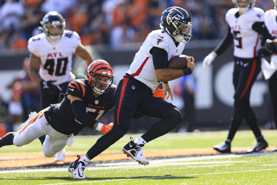 Atlanta Falcons quarterback Marcus Mariota (1) is chased by Cincinnati Bengals linebacker Markus Bailey (51) in the first half of an NFL football game in Cincinnati, Sunday, Oct. 23, 2022. (AP Photo/Aaron Doster)