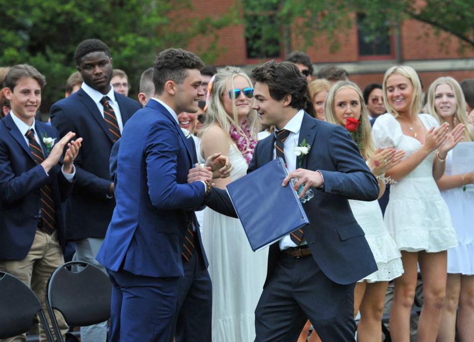 Dylan McDonough, left, congratulates senior speaker Ryan "Cooper" Mullen after his address during the Thayer Academy graduation in Braintree, Saturday, June 11, 2022.