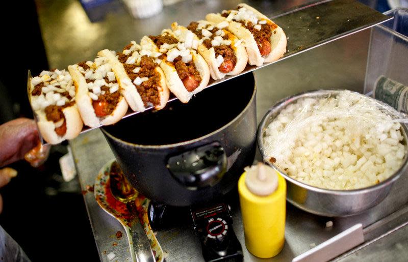 Coney dogs receive their toppings at Coney Island, Galesburg.