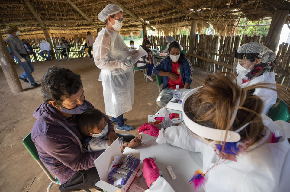 Health workers from the Butantan Institute test Guarani Mimbya Indigenous for COVID-19 in their community in Cananeia, Brazil, Friday, July 10, 2020. (AP Photo/Andre Penner)