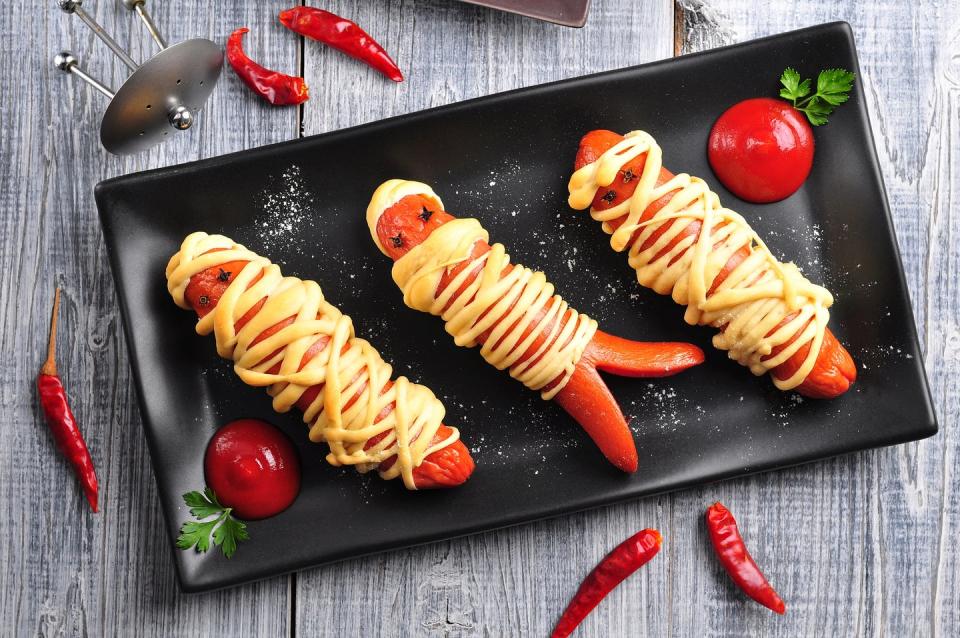 <p>Grill up some dogs or sausage! Once you're done, cut up pre-made dough into strips and start wrapping it around to achieve a mummy look. You can cut the bottoms to create "legs."</p>