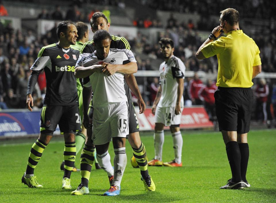 Swansea City's Wayne Routledge (R) is restrained by Stoke City's Erik Pieters after an incident with Stoke City goalkeeper Asmir Begovic during their English Premier League soccer match at the Liberty Stadium in Swansea, Wales, November 10, 2013.