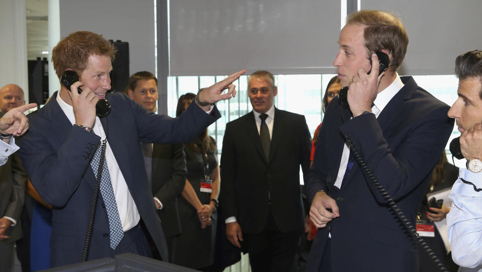 ARCHIVO - El príncipe Guillermo de Inglaterra, duque de Cambridge, derecha, y su hermano el príncipe Enrique participan en un intercambio de acciones en BGC Partners en el día benéfico de BGC 2013, en Canary Wharf, Londres, el 11 de septiembre de 2013. Documentos judiciales dicen que el príncipe Guillermo recibió en silencio “una suma muy grande de dinero” en un acuerdo por espionaje telefónico de 2020 con la editorial de diarios británica del imperio de medios de Rupert Murdoch. Los documentos judiciales emitidos el 25 de abril de 2023 en una de las demandas de su hermano contra los periódicos británicos dicen que el príncipe de Gales, heredero del trono británico, recibió discretamente un acuerdo en 2020. (Foto AP/ Chris Jackson, Pool, archivo)