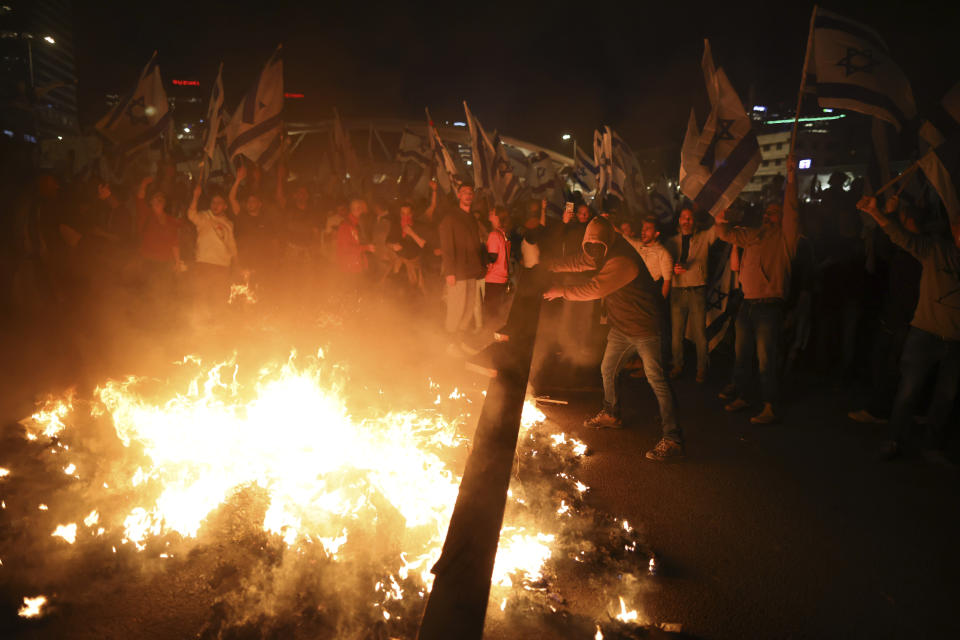 Israelis opposed to Prime Minister Benjamin Netanyahu's judicial overhaul plan set up bonfires and block a highway during a protest moments after the Israeli leader fired his defense minister, in Tel Aviv, Israel, Sunday, March 26, 2023. Defense Minister Yoav Gallant had called on Netanyahu to freeze the plan, citing deep divisions in the country and turmoil in the military. (AP Photo/Oren Ziv)