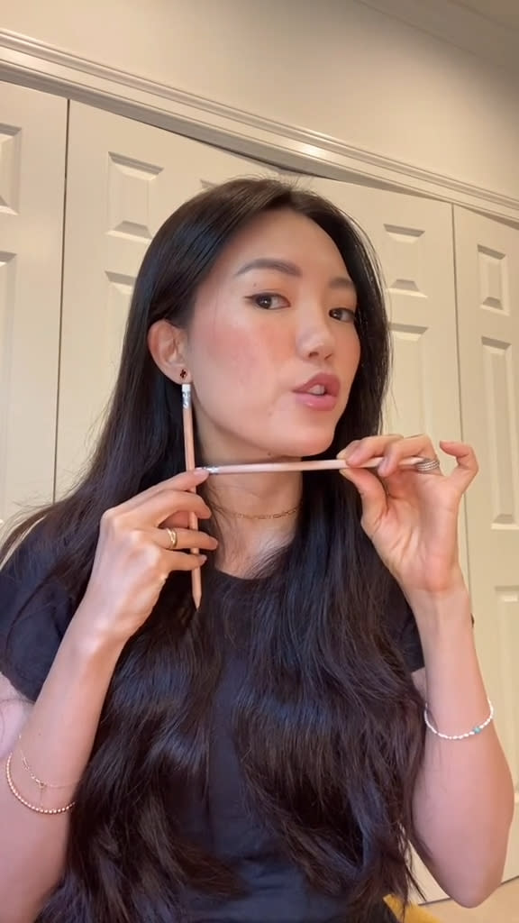 She used two pencils and a measuring tape to determine whether a bob would fit her face dimensions. @bondenavant/TikTok