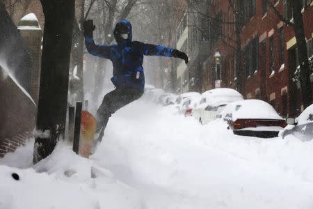 Fourteen-year-old Will Adam snow boards down a street on Beacon Hill during a large winter blizzard in Boston, Massachusetts January 27, 2015. REUTERS/Brian Snyder