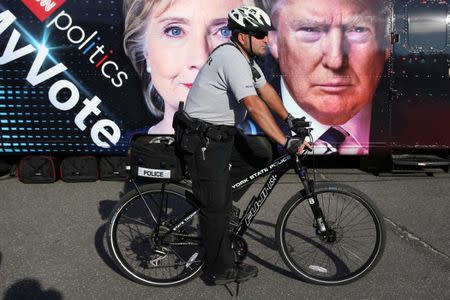 A member of the New York State police rides a bike on patrol outside Hofstra University, the site of the September 26 first presidential debate between U.S. Republican nominee Donald Trump and Democratic presidential nominee Hillary Clinton, in Hempstead, New York, U.S., September 26, 2016. REUTERS/Shannon Stapleton