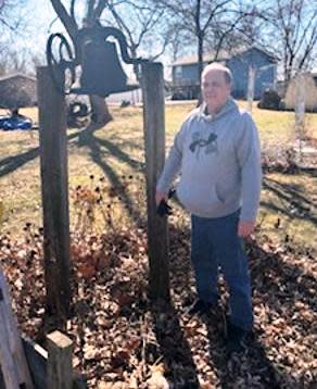 Rod Stanley poses for a photo near the school bell from Union #4 or Pleasant Hill School. The bell is now located in Stanley's yard.