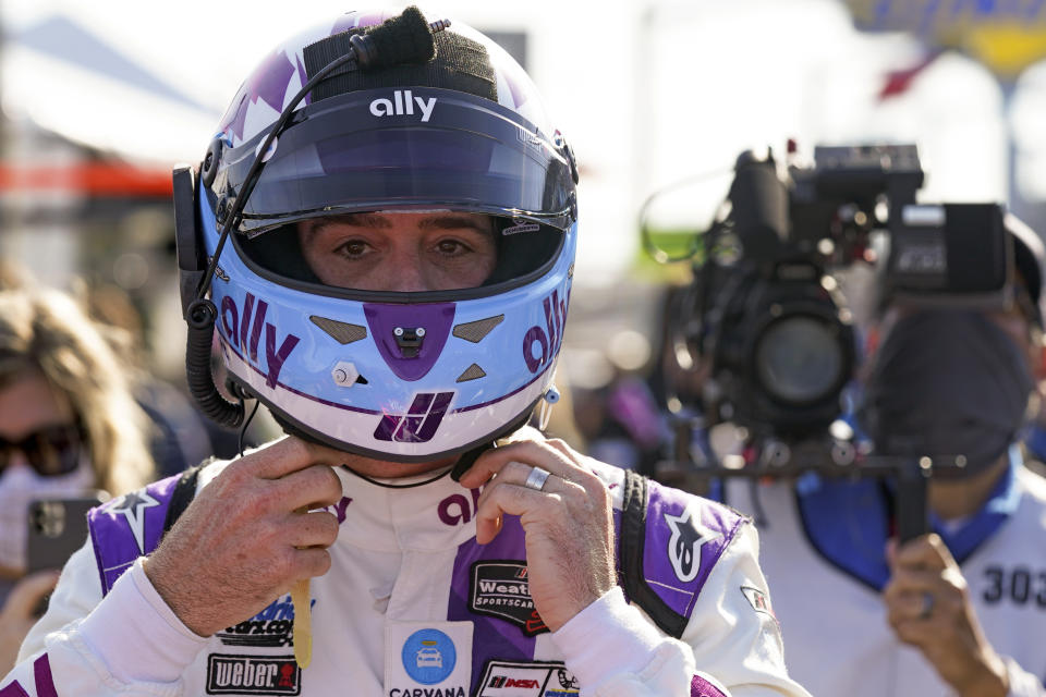 Jimmie Johnson prepares his helmet before getting in his car to start of the Rolex 24 hour auto race at Daytona International Speedway, Saturday, Jan. 30, 2021, in Daytona Beach, Fla. (AP Photo/John Raoux)