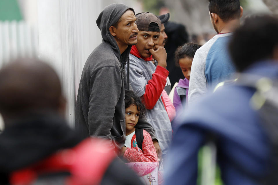 People wait to apply for asylum in the United States along the border Tuesday, July 16, 2019, in Tijuana, Mexico. Dozens of immigrants lined up Tuesday at a major Mexico border crossing, waiting to learn how the Trump administration's plans to end most asylum protections would affect their hopes of taking refuge in the United States. (AP Photo/Gregory Bull)