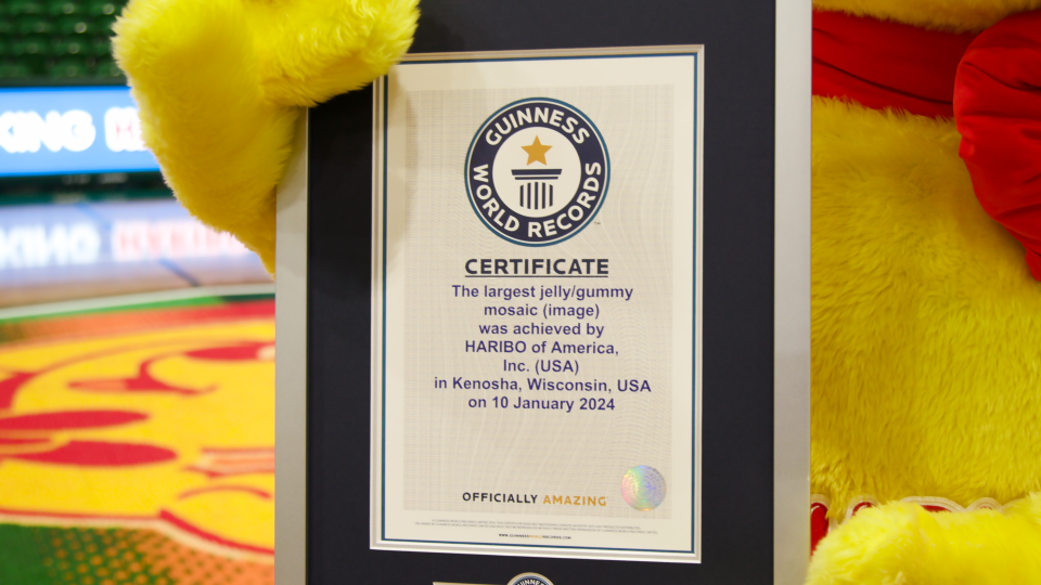 The Haribo bear mascot holds the Guinness World Records certificate the company earned for creating the largest jelly/gummy candy mosaic.