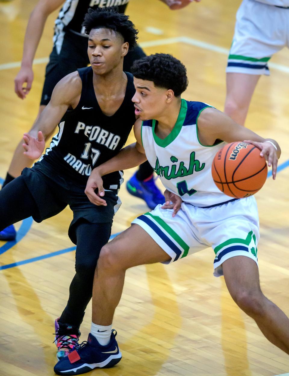 Peoria Notre Dame's Nelson Reynolds, right, tries to move the ball on Manual's Donald Wilson in the first half of the Class 3A regional title game Friday, Feb. 25, 2022 at Limestone High School in Bartonville. The Rams upset the Irish 36-33 in two overtimes.