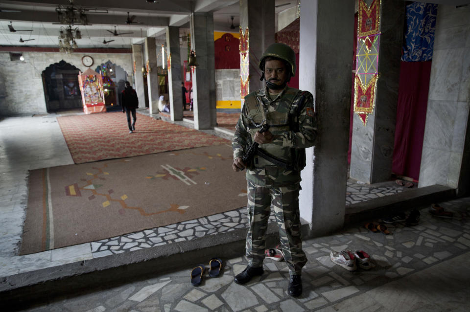 In this Wednesday, Oct. 31, 2018, photo, an Indian paramilitary soldier guards inside a Hindu temple in Srinagar, Indian controlled Kashmir. Synagogues, mosques, churches and other houses of worship are routinely at risk of attack in many parts of the world. And so worshippers themselves often feel the need for visible, tangible protection even as they seek the divine. (AP Photo/Dar Yasin)