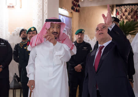 Saudi Arabia's King Salman bin Abdulaziz Al Saud (L) gestures as he welcomes Iraqi Prime Minister Haider Al-Abadi in Riyadh, Saudi Arabia October 21, 2017. Bandar Algaloud/Courtesy of Saudi Royal Court/Handout via REUTERS ATTENTION EDITORS - THIS PICTURE WAS PROVIDED BY A THIRD PARTY.