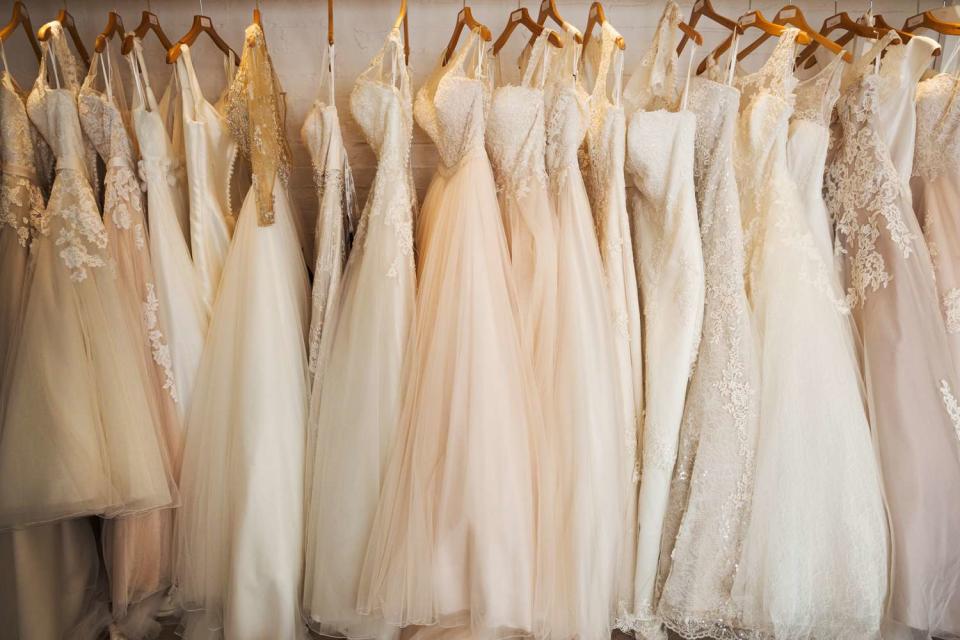 <p>Getty</p> Rows of wedding dresses on display in a specialist wedding dress shop. A variety of colour tones and styles, fashionable lace and boned bodices.