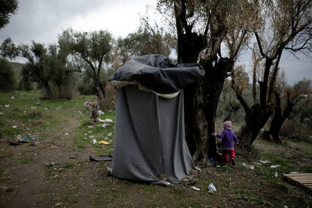 A girl walks next to a self-made shower at a makeshift camp for refugees and migrants next to the Moria camp on the island of Lesbos, Greece, November 30, 2017. REUTERS/Alkis Konstantinidis